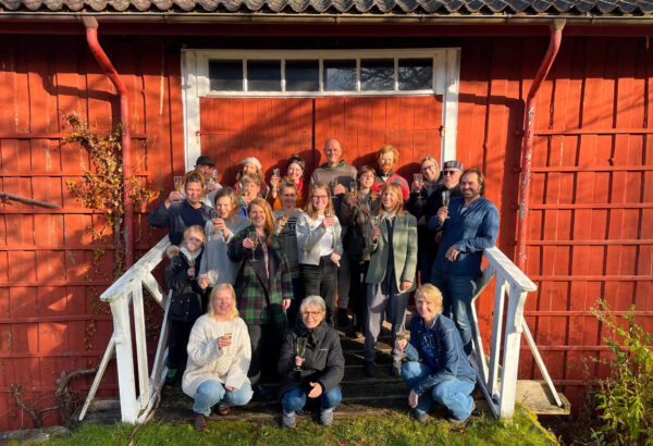 Hela gänget i Nordfrö och Runåbergs fröer fotograferade mot en faluröd husvägg.
